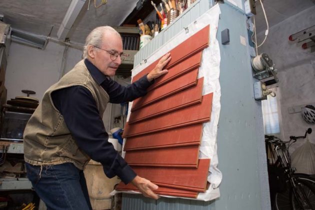 NEW APPROACH: Howard Newman, owner of Newport art-restoration company Newman Ltd., demonstrates a patent-pending invention for a new way of putting siding on buildings. / PBN PHOTO/KATE WHITNEY LUCEY