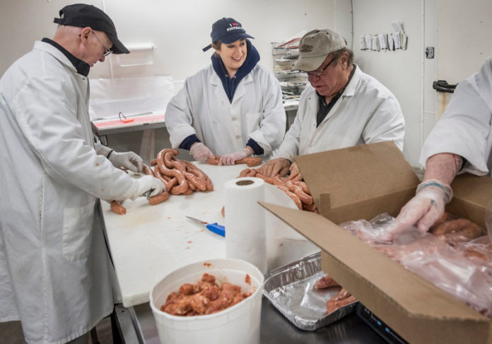 PERSONAL TOUCH: Kelly Thomas, owner of Becoming Italian Today, with her crew packaging sausages in South Kingstown. From left, Paul Constanza; Thomas; her father, Charlie Thomas; and Scott Goodenough. / PBN PHOTO/MICHAEL SALERNO