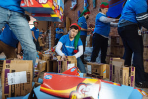 GIVING BACK: Tayla Reo, center, who works in Hasbro Inc.'s global brand licensing and publishing group, spends her morning on Dec. 15 packaging Hasbro toys destined for children. / PBN PHOTO/RUPERT WHITELEY