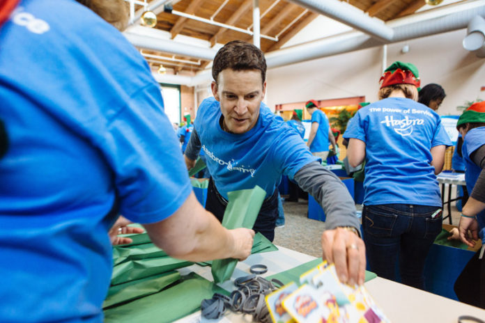 JOINING IN THE FUN: Hasbro Chairman, CEO and President Brian Goldner took part on Dec. 15 in a company-wide effort at its Pawtucket headquarters to pack toys for children and families. / PBN PHOTO/ RUPERT WHITELEY
