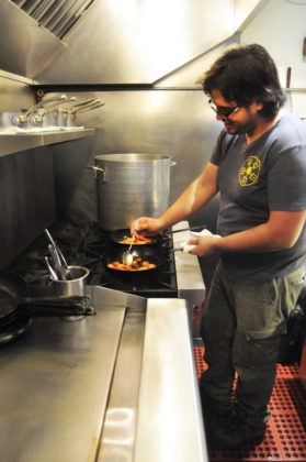 HOT TICKET: James Mark, owner and chef at north in Providence, prepares one of his dishes. North has 20 seats in the dining room, and seven at the bar. North bakery, which Mark also owns, seats 15. / PBN FILE PHOTO/FRANK MULLIN