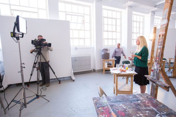 SARAH WHITCOMB FOSS, a member of Jeopardy!'s Clue Crew, is shown with paints in a studio at the Rhode Island School of Design during an August visit. The television game show visited the campus to film clues for a category on RISD. The show will air Friday. / COURTESY JO SITTENFELD/RISD