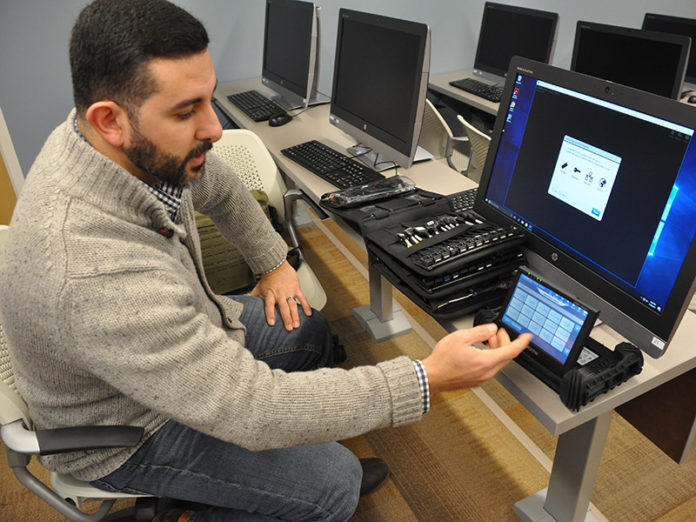 BRANDON CATALAN, who teaches courses in mobile forensics and principles of forensics at Salve Regina University, launches Cellebrite software on new equipment housed in the Administration of Justice department’s new digital forensics lab. Salve Regina is one of two higher educational institutions in New England – and the only in Rhode Island – to be named an official partner of Cellebrite. / COURTESY SALVE REGINA UNIVERSITY