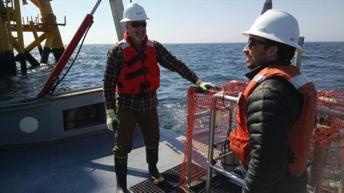KEEPING WATCH: INSPIRE Environmental team members Jimmy Flynn, left, a marine scientist, and Ben Taylor, a geographic information system analyst, visit the Block Island Wind Farm in March 2016, prior to the installation of blades and the wind generator. / COURTESY INSPIRE ENVIRONMENTAL/STEVE SABO