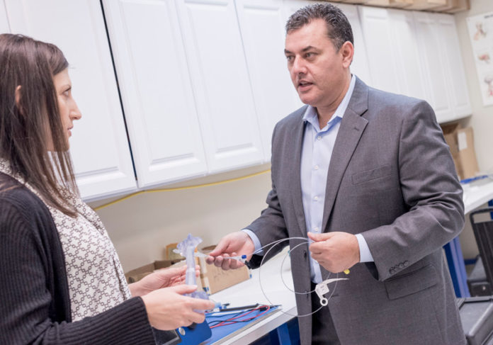 LIGHTING THE WAY: IlluminOss Medical's pioneering technology, which uses light-hardened polymers in a minimally invasive technology to repair broken bones, got one step closer to FDA approval, as it started its first U.S. clinical trials in 2016. Manny Avila, president and CEO of the East Providence company, speaks with Amy O. Berman, vice president of clinical affairs. / PBN FILE PHOTO/ MICHAEL SALERNO