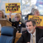 BURRILLVILLE attorney Michael McElroy speaking to the R.I. Energy Facility Siting Board in February with a group opposing the proposed power plant in the background. PBN FILE PHOTO/MICHAEL SALERNO