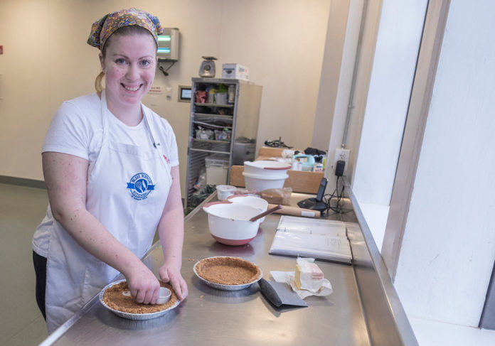 CREATIVE TREATS: Ashley Nichols, owner of The Flaky Crust Pie Bakery, works on a pie with a graham-cracker crust. / PBN PHOTO/MICHAEL SALERNO CREATIVE TREATS: Ashley Nichols, owner of The Flaky Crust Pie Bakery, works on a pie with a graham-cracker crust. / PBN PHOTO/MICHAEL SALERNO