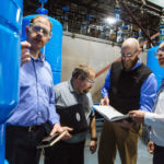 MAKING PROGRESS TOGETHER: Amtrol believes that collaboration yields successful product innovation. Examining one of the company's hydrology products are, from left: Chris Kampf, director of product innovation; Joe Jeannotte, product engineer; Michael Cogliati, R&D engineering; and Chris Van Haaren, senior vice president of engineering. / PBN PHOTO/RUPERT WHITELEY