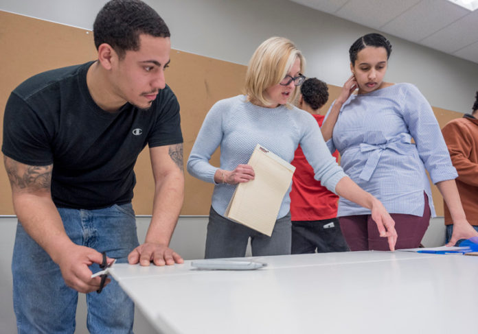 TEACHABLE MOMENTS: Brickle Group employees Roddy Rodriguez, left, and Belanie Medina, right, take part in a Manufacturing Center of Excellence class being taught at the New England Institute of Technology by mechanical-engineering instructor Annie Unger. / PBN PHOTO/MICHAEL SALERNO