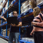 MEETING TIME-CRITICAL NEEDS: Joe Aguiar, left, senior associate, supply chain, and Kacey Fetcho, senior manager, supply chain, inspect inventory at Amgen Rhode Island's West Greenwich manufacturing facility. / PBN PHOTO/RUPERT WHITELEY