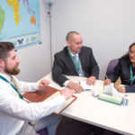 ON A MISSION: From left, Neighborhood Health Plan of Rhode Island officials Ed Curis, policy analyst; David Burnett, chief of staff; and Ericka Moore, sales and marketing representative, meet at the nonprofit’s Providence office. / PBN PHOTO/TRACY JENKINS