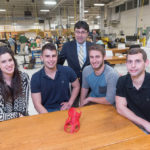 INNOVATIVE ­DESIGN: University of Rhode Island engineering students designed a new scoliosis brace and printed a 1/25-scale model prototype on a 3-D printer. From left, Gabriella Divine, a fifth-year mechanical-engineering and Spanish major from East Greenwich; Chris Viveiros, a mechanical-engineering senior from Attleboro; URI professor Bahram Nassersharif; Dan Cross, a mechanical-engineering senior from Northborough, Mass.; and Thomas Brey, a mechanical-engineering senior from Manville, N.Y. / PBN PHOTO/­MICHAEL SALERNO