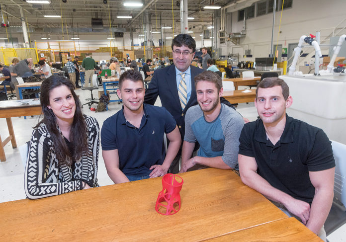 INNOVATIVE ­DESIGN: University of Rhode Island engineering students designed a new scoliosis brace and printed a 1/25-scale model prototype on a 3-D printer. From left, Gabriella Divine, a fifth-year mechanical-engineering and Spanish major from East Greenwich; Chris Viveiros, a mechanical-engineering senior from Attleboro; URI professor Bahram Nassersharif; Dan Cross, a mechanical-engineering senior from Northborough, Mass.; and Thomas Brey, a mechanical-engineering senior from Manville, N.Y. / PBN PHOTO/­MICHAEL SALERNO