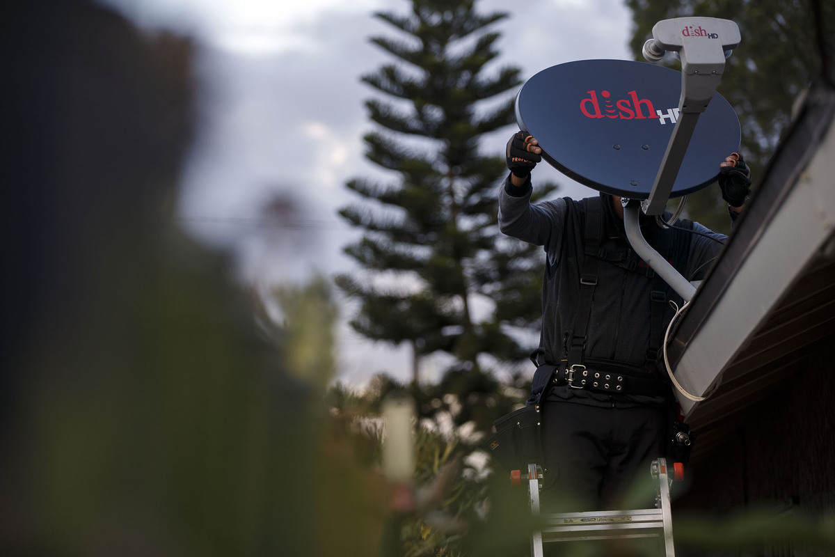 A DISH Network Corp. field service specialist installs a satellite television system at a residence in Downey, Calif. U.S. cable and satellite-TV providers suffered their worst first quarter of subscriber losses in history, raising fresh concerns that cord-cutting will accelerate and drag down media stocks. / BLOOMBERG NEWS PHOTO/ PATRICK T. FALLON