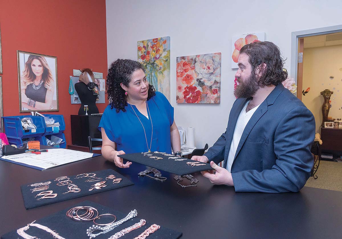 NEXT GENERATION, NEW APPROACH: Felice Porcaro Silvia, president of Uncas International, speaks with her brother, Felix A. Porcaro III, at the company facility in West Warwick. Since buying their father’s jewelry company, Crimzon Rose, they have focused on expanding product lines and customers.  / PBN PHOTO/MICHAEL SALERNO