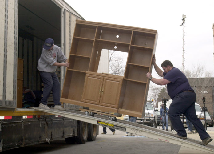 Moving company employees remove furniture from a business in Chicago, Illinois. COURTESY BLOOMBERG/ TANNEN MAURY