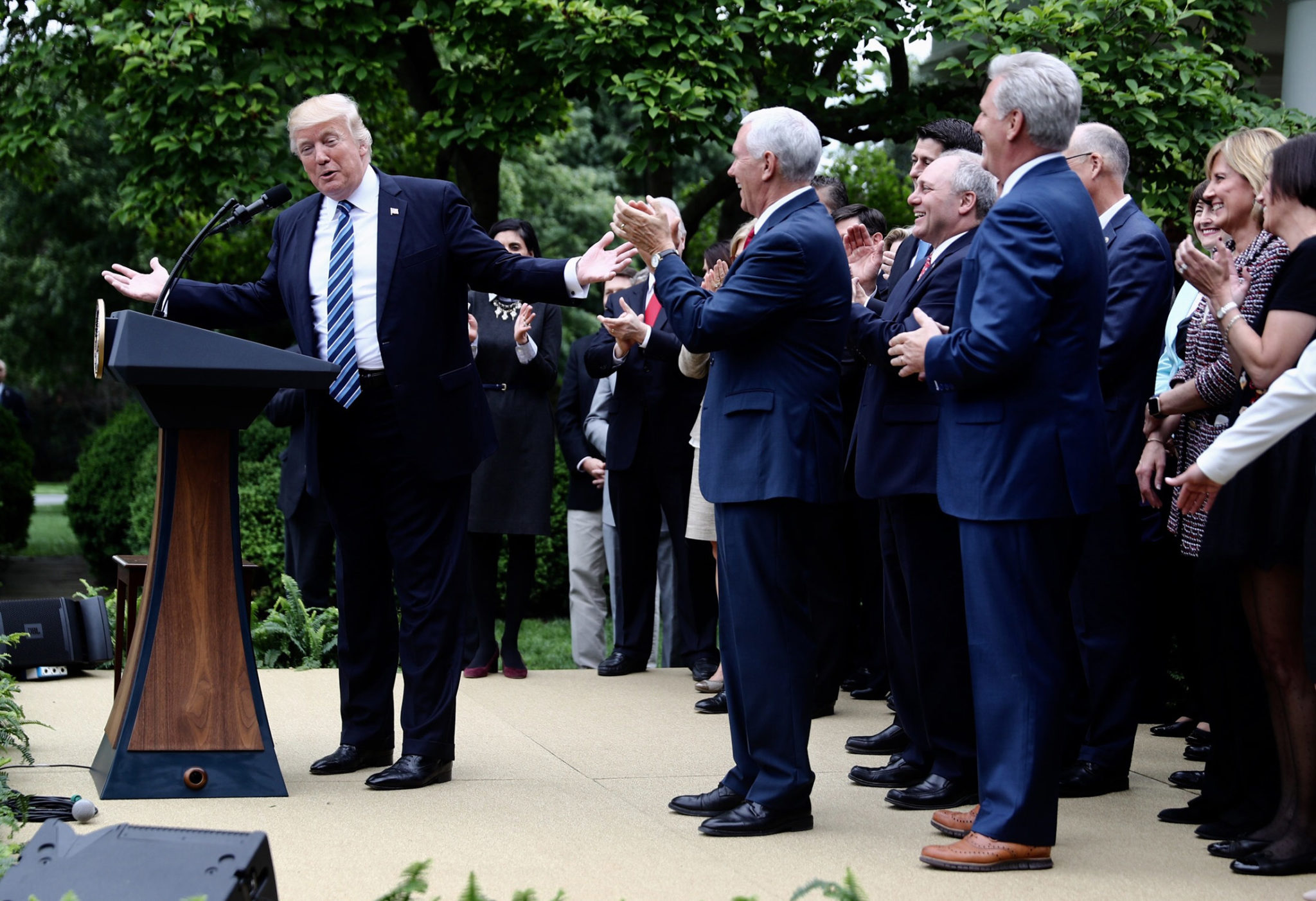 U.S. President Donald Trump, left, speaks as U.S. Vice President Mike Pence, center, applauds during a press conference in the Rose Garden of the White House in Washington, D.C., U.S., on Thursday. House Republicans mustered just enough votes to pass their health-care bill Thursday, salvaging what at times appeared to be a doomed mission to repeal and partially replace Obamacare under intense pressure from Trump to produce legislative accomplishments. / BLOOMBERG / ANDREW HARRER