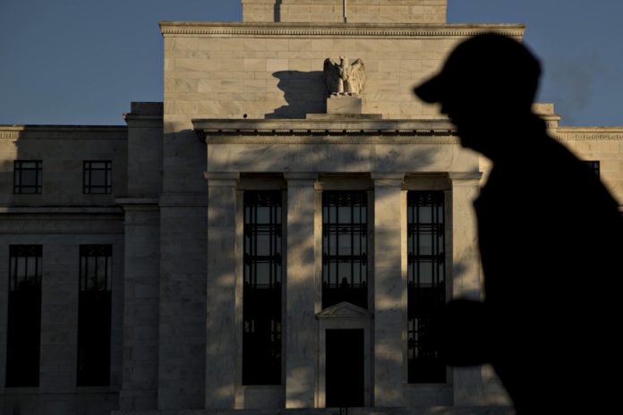 A runner passes the Marriner S. Eccles Federal Reserve building in Washington, D.C., U.S., on Friday, Nov. 18, 2016. Federal Reserve Chair Janet Yellen told lawmakers on Thursday that she intends to stay in the job until her term expires in January 2018 while extolling the virtues of the Fed's independence from political interference. / BLOOMBERG / ANDREW HARRER