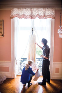 PICTURE PERFECT: Blueflash Photography team members prepare a wedding dress to be photographed at a Rhode Island wedding venue. / COURTESY BLUEFLASH PHOTOGRAPHY