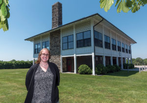 SOUGHT-AFTER DESTINATION: Daisy MacLeod, event coordinator for the Kinney Bungalow, stands in front of the structure that was built in 1899 for post-polo match parties. Opened to the public in 2002 by the town of Narragansett, it is now a sought-after wedding venue. / PBN PHOTO/MICHAEL SALERNO