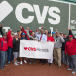 VETERANS FROM ACROSS New England pose on the field at Fenway Park at the CVS Health Baseball Skills Camp for Veterans – a special event for veterans hosted by CVS Health in partnership with the Boston Red Sox. /COURTESY CONSTANCE BROWN PHOTOGRAPHY