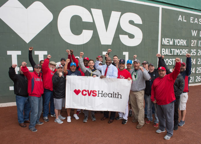 VETERANS FROM ACROSS New England pose on the field at Fenway Park at the CVS Health Baseball Skills Camp for Veterans – a special event for veterans hosted by CVS Health in partnership with the Boston Red Sox. /COURTESY CONSTANCE BROWN PHOTOGRAPHY