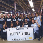 A PASSION FOR CARING: Blue Cross & Blue Shield of Rhode Island employees are given eight hours of paid time per year to volunteer. Here, they volunteer at Recycle-A-Bike in Cranston. / COURTESY BLUE CROSS & BLUE SHIELD OF RHODE ISLAND