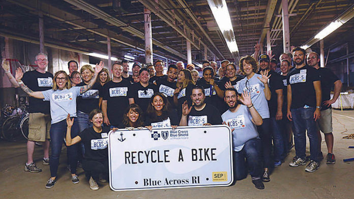 A PASSION FOR CARING: Blue Cross & Blue Shield of Rhode Island employees are given eight hours of paid time per year to volunteer. Here, they volunteer at Recycle-A-Bike in Cranston. / COURTESY BLUE CROSS & BLUE SHIELD OF RHODE ISLAND