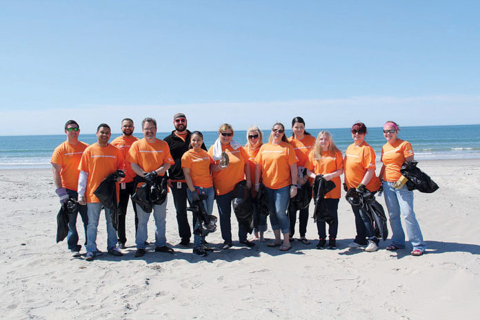 MAKING A DIFFERENCE: Embrace Home Loans supports staff volunteering efforts, such as cleaning up the Ocean State’s beaches. / COURTESY EMBRACE HOME LOANS