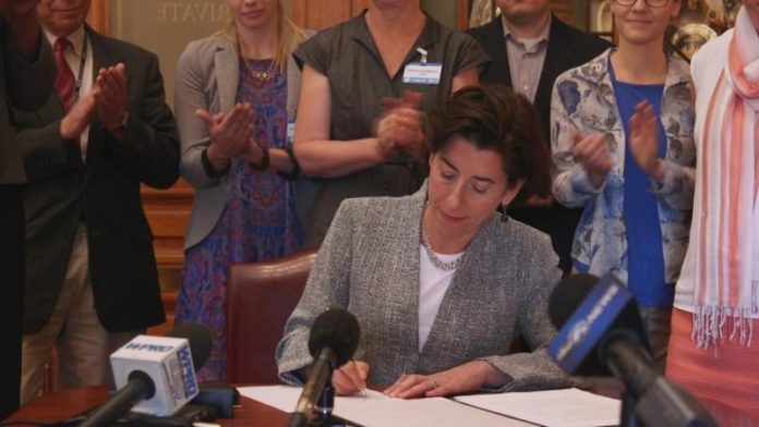 GOV. GINA M. RAIMONDO SIGNS an executive order to reaffirm Rhode Island's commitment to the principles of the Paris Climate Accord on Monday. / COURTESY THE OFFICE OF THE GOVERNOR OF RHODE ISLAND