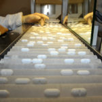 AN EMPLOYEE USES a machine that sorts pills. / BLOOMBERG FILE PHOTO/ANTOINE ANITONIOL