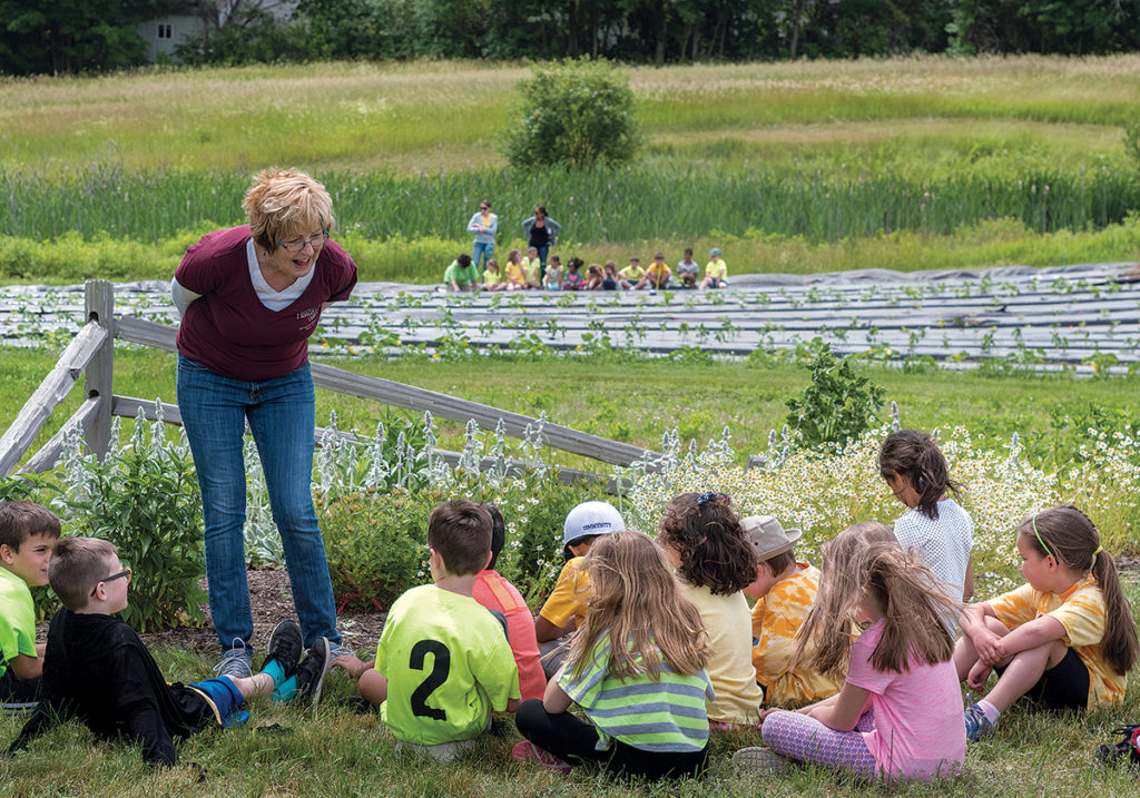 EDUCATION & DONATION: Pamela Thurlow, president of the Historic Metcalf-Franklin Farm Preservation Association in Cumberland, gives a talk to first-graders from Community School about herbs grown on the farm, which donates an average of 16,044 pounds of fresh fruits and vegetables each year to the Rhode Island Community Food Bank. / PBN PHOTO/MICHAEL SALERNO