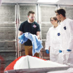 IYRS SCHOOL OF Technology and Trades student Andrew Leonard, black T-shirt, shows Massachusetts Institute of Technology students Carrie McKnelly and Tyler Crain how to prepare a mold for a lightweight canoe. The IYRS campus in Bristol is one example of the East Bay's concentration of composites expertise, which a new $125,000 federal grant from the U.S. Economic Development Administration aims to tap into. /COURTESY MICHAEL CAMERON
