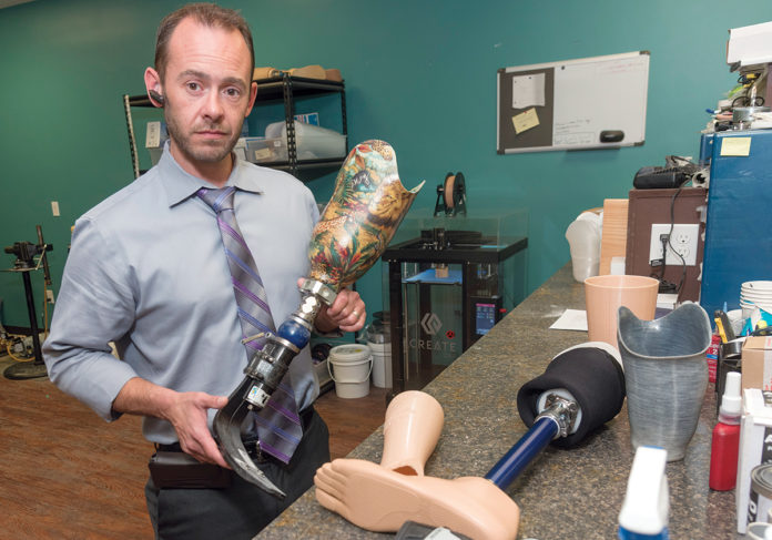 HANDS-ON: Jonathan Teoli, owner of Rhode Island Limb Co. in Cranston, works with some of the prosthetics he produces. He designs and fits each device by hand. / PBN PHOTO/MICHAEL SALERNO HANDS-ON: Jonathan Teoli, owner of Rhode Island Limb Co. in Cranston, works with some of the prosthetics he produces. He designs and fits each device by hand. / PBN PHOTO/MICHAEL SALERNO
