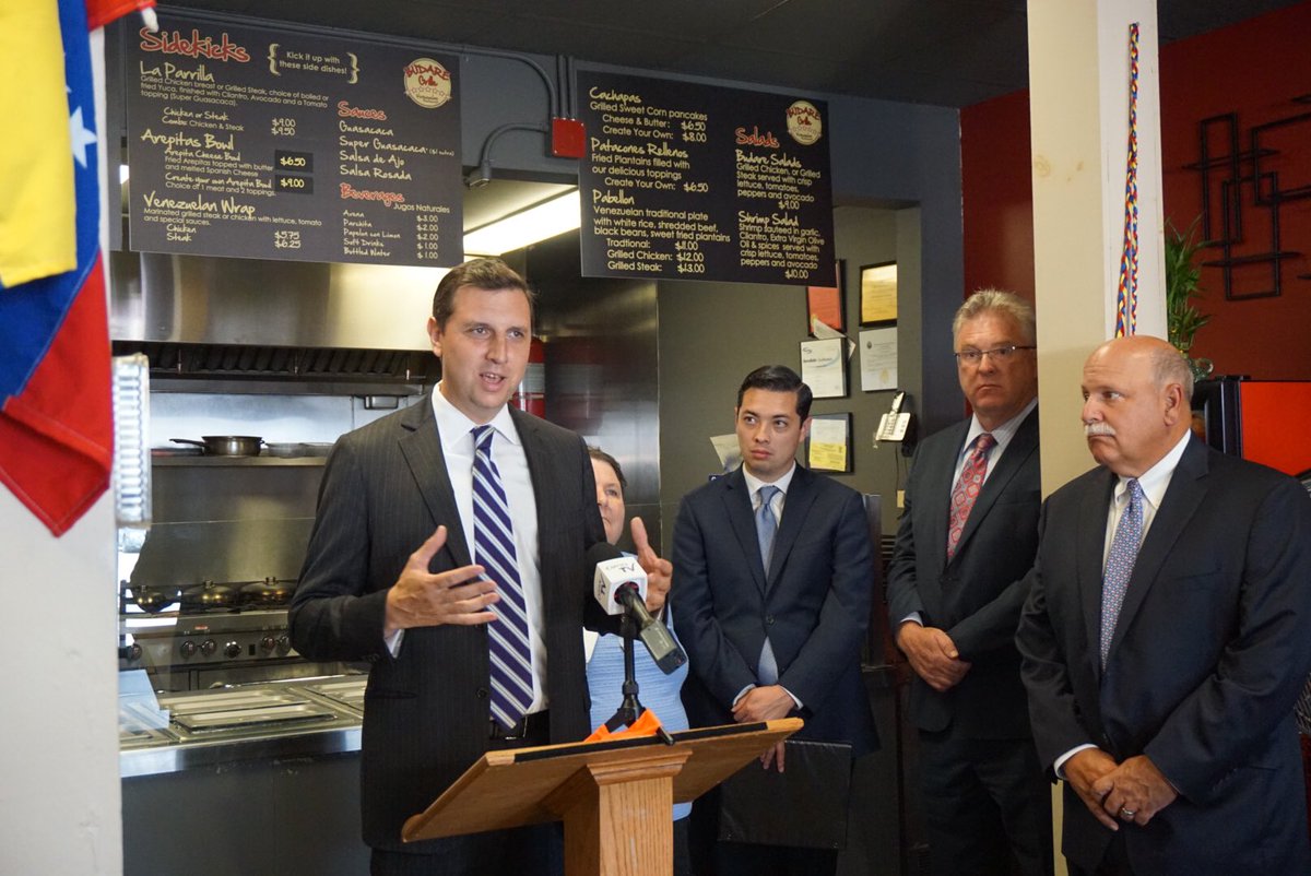 GENERAL TREASURER Seth Magaziner, left, celebrates moving $15 million in state deposits to local banks and credit unions at Budare Grille in Central Falls in August./ COURTESY R.I OFFICE OF THE GENERAL TREASURER