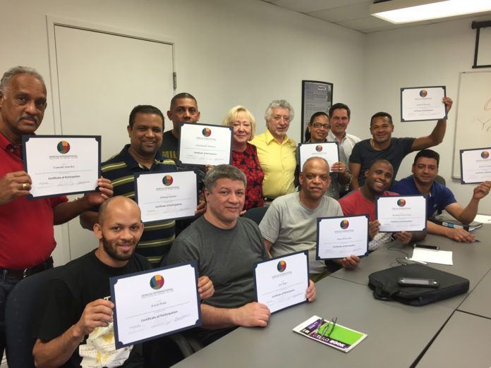 MEARTHANE PRODUCTS CORP. employees hold their certificates after graduating from an English language learners course that was offered by the company in partnership with the Dorcas International Institute of Rhode Island. /COURTESY MEARTHANE PRODUCTS CORP.