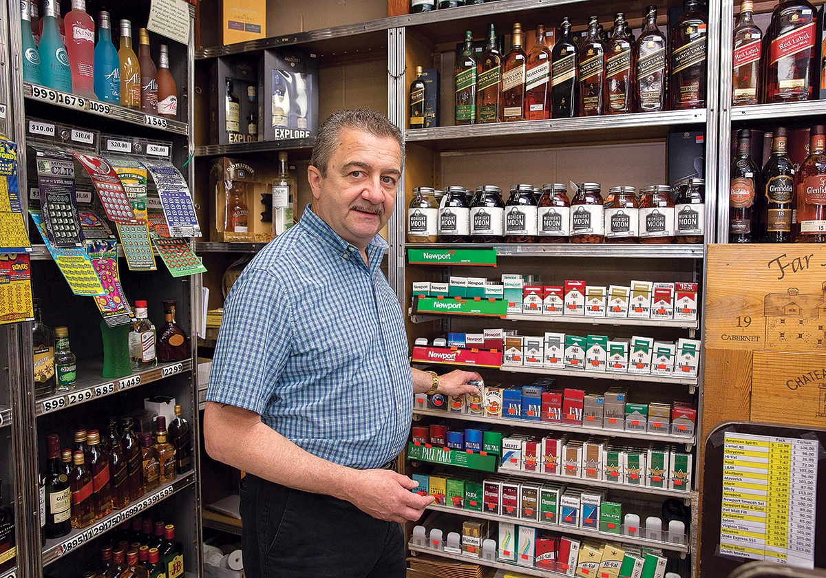 HIGHER COST: Tom Saccoccia is the owner of Sak’s Centredale Liquor and Wine Cellar in North Providence. He says his customers have noticed the higher cost of a pack of cigarettes, now $8 to $11.50, following the state’s increased cigarette excise tax.  / PBN PHOTO/TRACY JENKINS