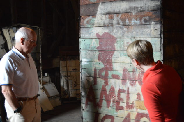 Matt Hird, a member of the congregation at the Beneficent Congregational Church, and Caroline Stevens, director of Doors Open Rhode Island, admire graffiti – circa 1948 – on a chimney inside the church dome. PBN PHOTO/NICOLE DOTZENROD