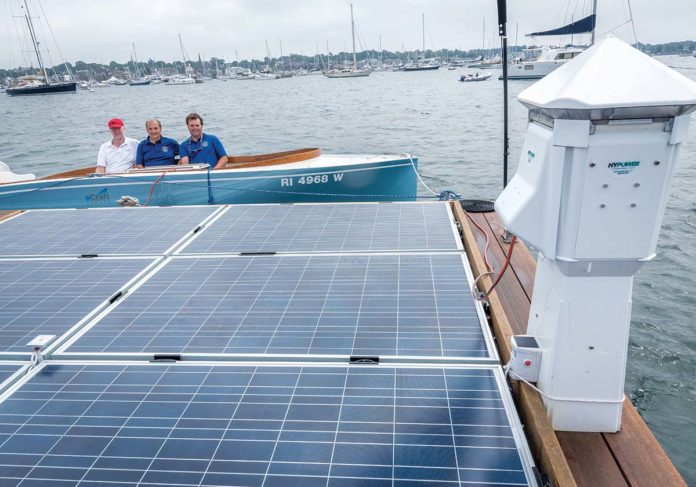 CHARGED UP: PowerDocks has placed a 20-by-20-foot charging platform in Newport harbor. Using it with an eCraft boat are, from left, Rufus Van Gruisen, president of Cay Electronics Inc. and eCraft Yachts; Anthony Baro, managing partner of PowerDocks; and Chris Fagan, principal of PowerDocks. / PBN PHOTO/MICHAEL SALERNO CHARGED UP: PowerDocks has placed a 20-by-20-foot charging platform in Newport harbor. Using it with an eCraft boat are, from left, Rufus Van Gruisen, president of Cay Electronics Inc. and eCraft Yachts; Anthony Baro, managing partner of PowerDocks; and Chris Fagan, principal of PowerDocks. / PBN PHOTO/MICHAEL SALERNO