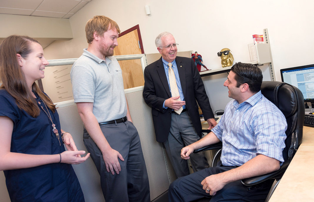 TEAM APPROACH: Donald R. Nokes, president and founder of NetCenergy, an information technology services firm, converses with employees at their Cranston office. From left, Kelsey Nokes, manager, business systems; Greg Morrell, network engineer; Donald R. Nokes, president; and Chris Aloisio, lead engineer. / PBN PHOTO/MICHAEL SALERNO TEAM APPROACH: Donald R. Nokes, president and founder of NetCenergy, an information technology services firm, converses with employees at their Cranston office. From left, Kelsey Nokes, manager, business systems; Greg Morrell, network engineer; Donald R. Nokes, president; and Chris Aloisio, lead engineer. / PBN PHOTO/MICHAEL SALERNO