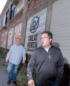 GROWTH SIGN: Pawtucket Mayor Donald R. Grebien, left, meets with Isle Brewers Guild co-founder Jeremy Duffy during a walking tour of the city’s downtown. Grebien cites IBG as an example of increased economic activity in the area. / PBN PHOTO/MICHAEL SALERNO 