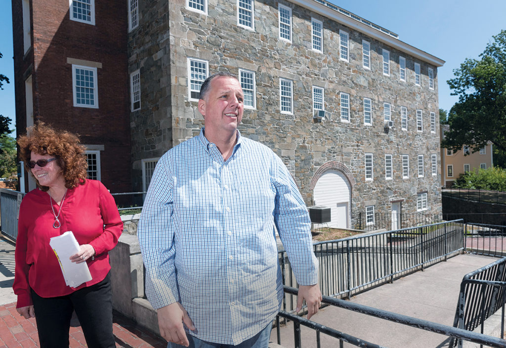 BIG PLANS: Pawtucket Mayor Donald R. ­Grebien and Jeanne Boyle, city commerce director, conduct a walking tour of the downtown area. They are in front of the former Wilkinson Mill building. / PBN PHOTO/­MICHAEL SALERNO