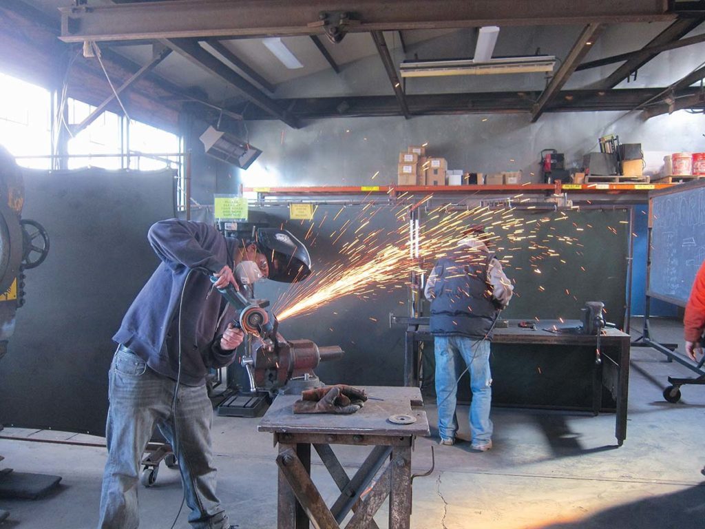 TAKING SHAPE: Participants in The Steel Yard’s Weld-to-Work program work on bike racks installed this year in 16 Rhode Island communities. / COURTESY THE STEEL YARD