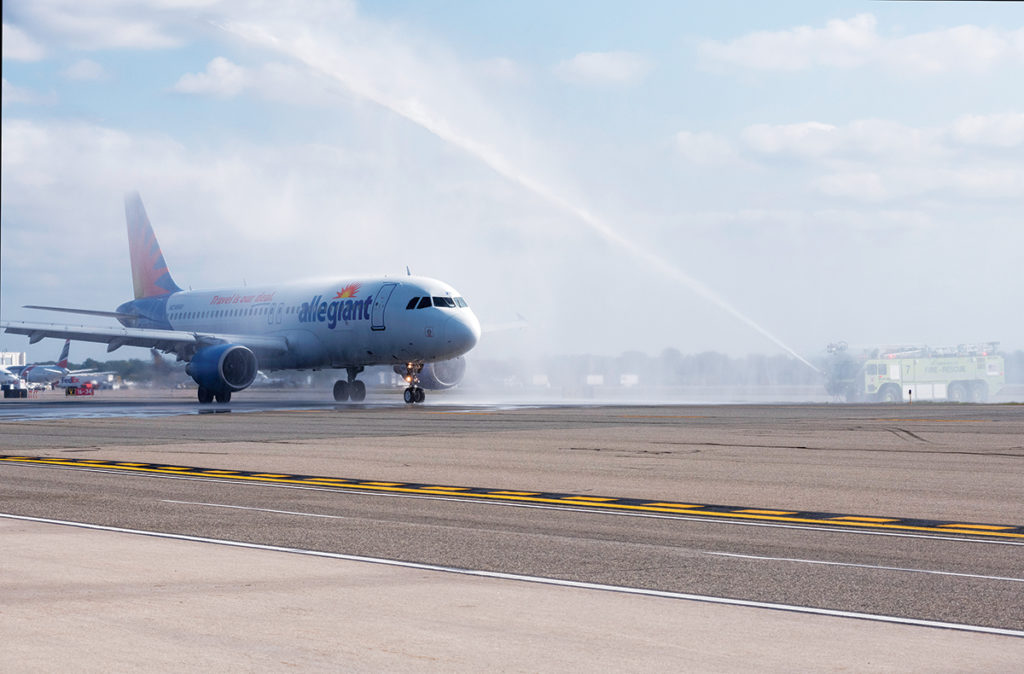 WELCOMING ALLEGIANT: A fire engine shoots a stream of water into the air in celebration of the first flight of Allegiant Air, which serves several airports in Florida with direct service, arriving at T.F. Green Airport. / PBN PHOTO/MICHAEL SALERNO