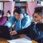 NO SAGE-ON-A-STAGE: Academy for Career Exploration teacher Denise Burke, center, helps Jamie Pagan with a lesson. The school has overhauled its curriculum and approach, and turned itself around as a result. / PBN PHOTO/RUPERT WHITELEY