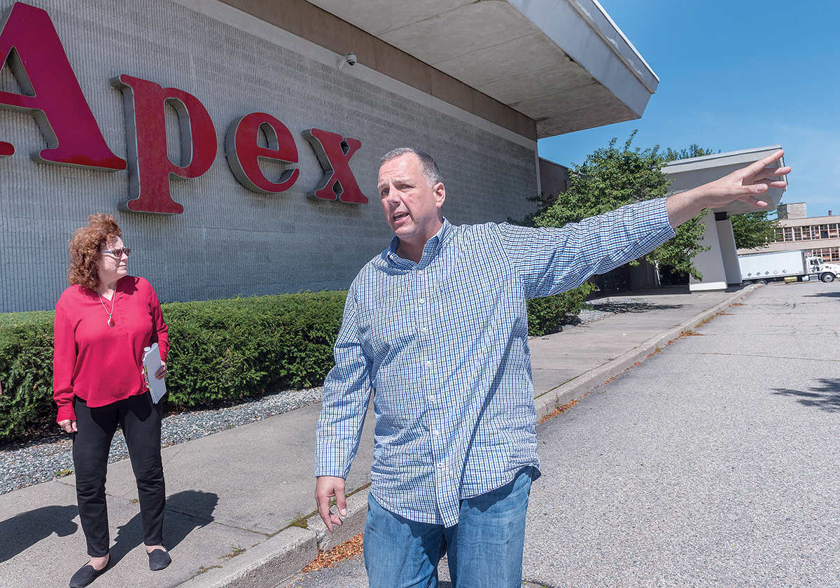 PROPOSED SITE: The Apex Department Store building in Pawtucket, the proposed location of a new PawSox ballpark, can be seen in the background during a walking tour of the city’s downtown area with Mayor ­Donald R. Grebien and Commerce Director Jeanne Boyle. / PBN PHOTO/MICHAEL SALERNO