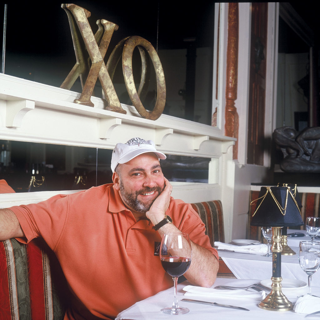 CELEBRATION: Chef John Elkhay, maestro of Chow Fun Food Group, at the table at his XO Café restaurant, which is offering menu prices from 1997 for a limited time in December in celebration of 20 years in Providence. / COURTESY CHOW FUN FOOD GROUP