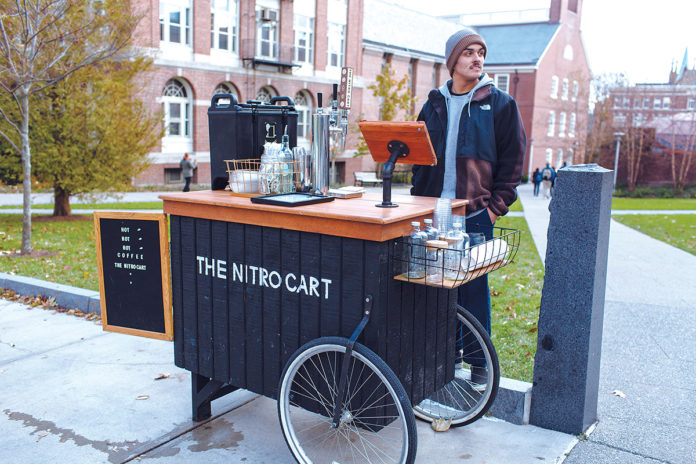 MOBILE COFFEE: Cole Criollos operates one of two of The Nitro Cart’s mobile coffee carts in Providence’s West Side neighborhood. The company was launched in 2016 by co-owners Audrey Finocchiaro and Sam Lancaster. / PBN PHOTO/RUPERT WHITELEY