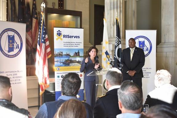 GOV. GINA M. RAIMONDO at the podium next to Director of Veterans Affairs Kasim Yarn at the launch of RIServes, a coordinated network of public, private and nonprofit organizations designed to help service members, veterans and their families find services they need in Rhode Island. / COURTESY R.I. OFFICE OF VETERANS AFFAIRS