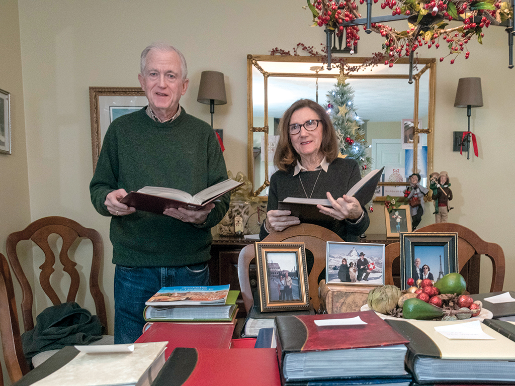 EDUCATIONAL EXPERIENCES: Timothy and Susan Magill of Narragansett, with the many photo albums from their eight different tours with Collette. The couple wants to learn from new cultures and continues to book with Collette because of the educational experiences. / PBN PHOTO/MICHAEL SALERNO